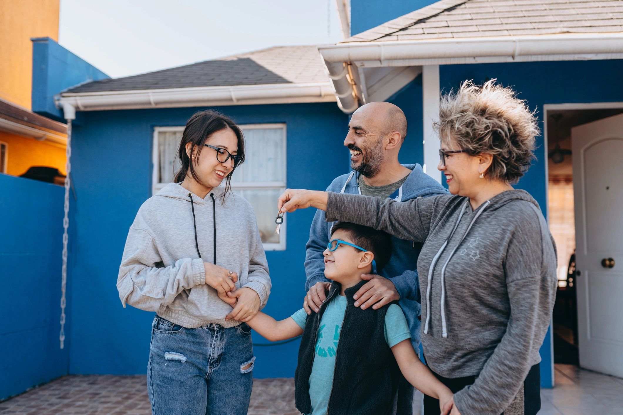 Familia frente a una casa en barrio residencial